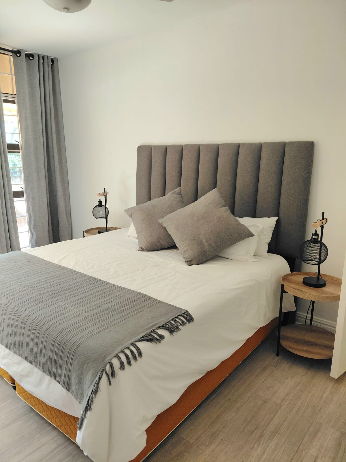 Channel tufted grey headboard in modern bedroom