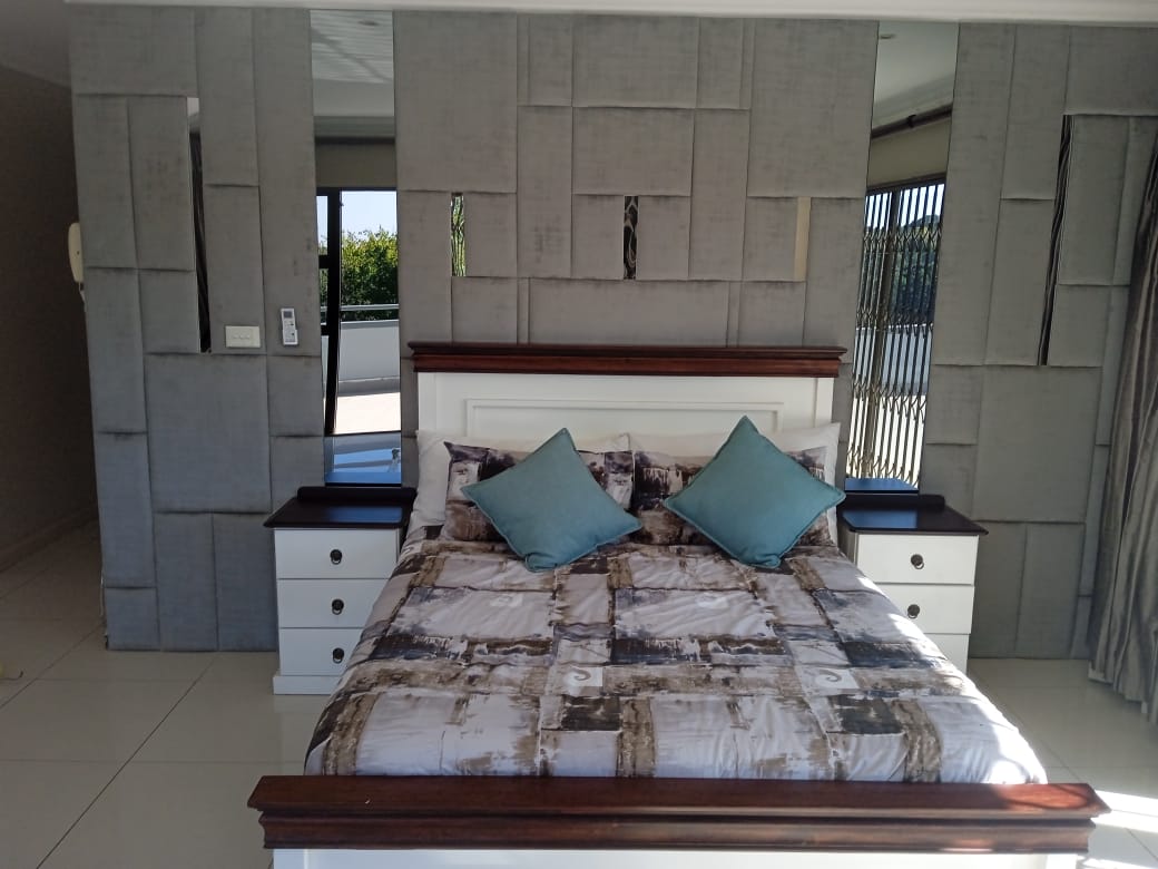 Grey upholstered wall panels with bed